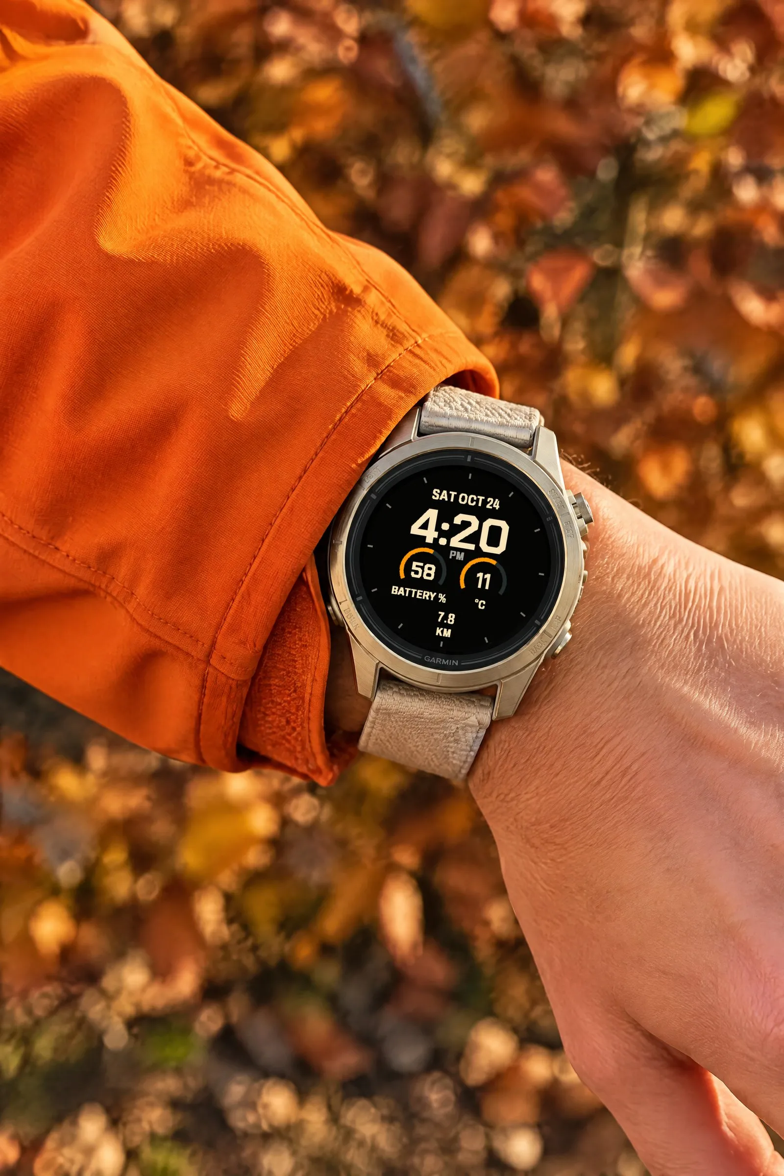Garmin epix Pro with the Fieldline watch face in Cream / Orange and the On the go layout against the sleeve of an orange jacket