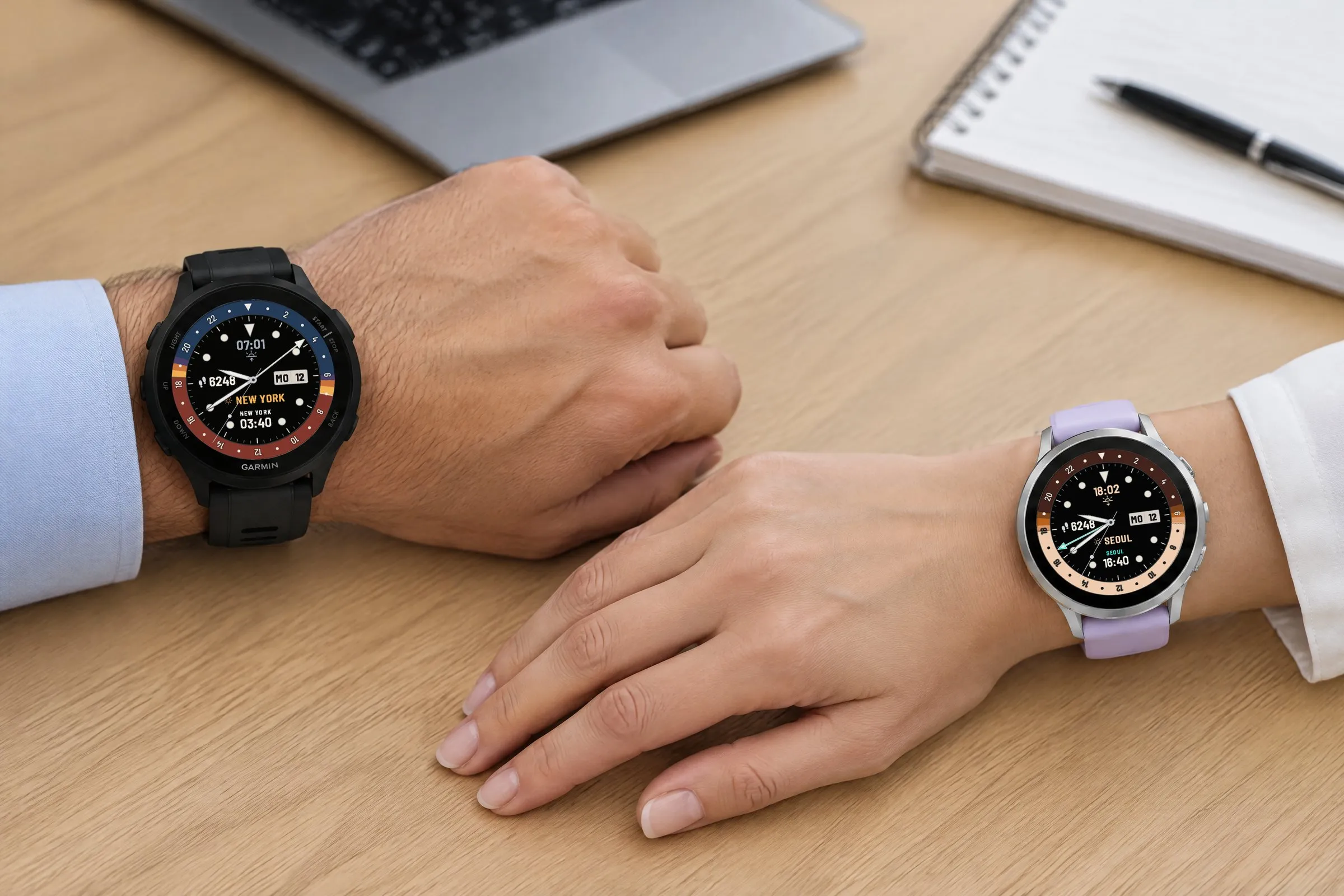 Two Garmin watches with Horizon GMT at a meeting table: Forerunner 165 with Free in Classic and New York as second time zone, Venu 4 with Pro in Chestnut and Seoul