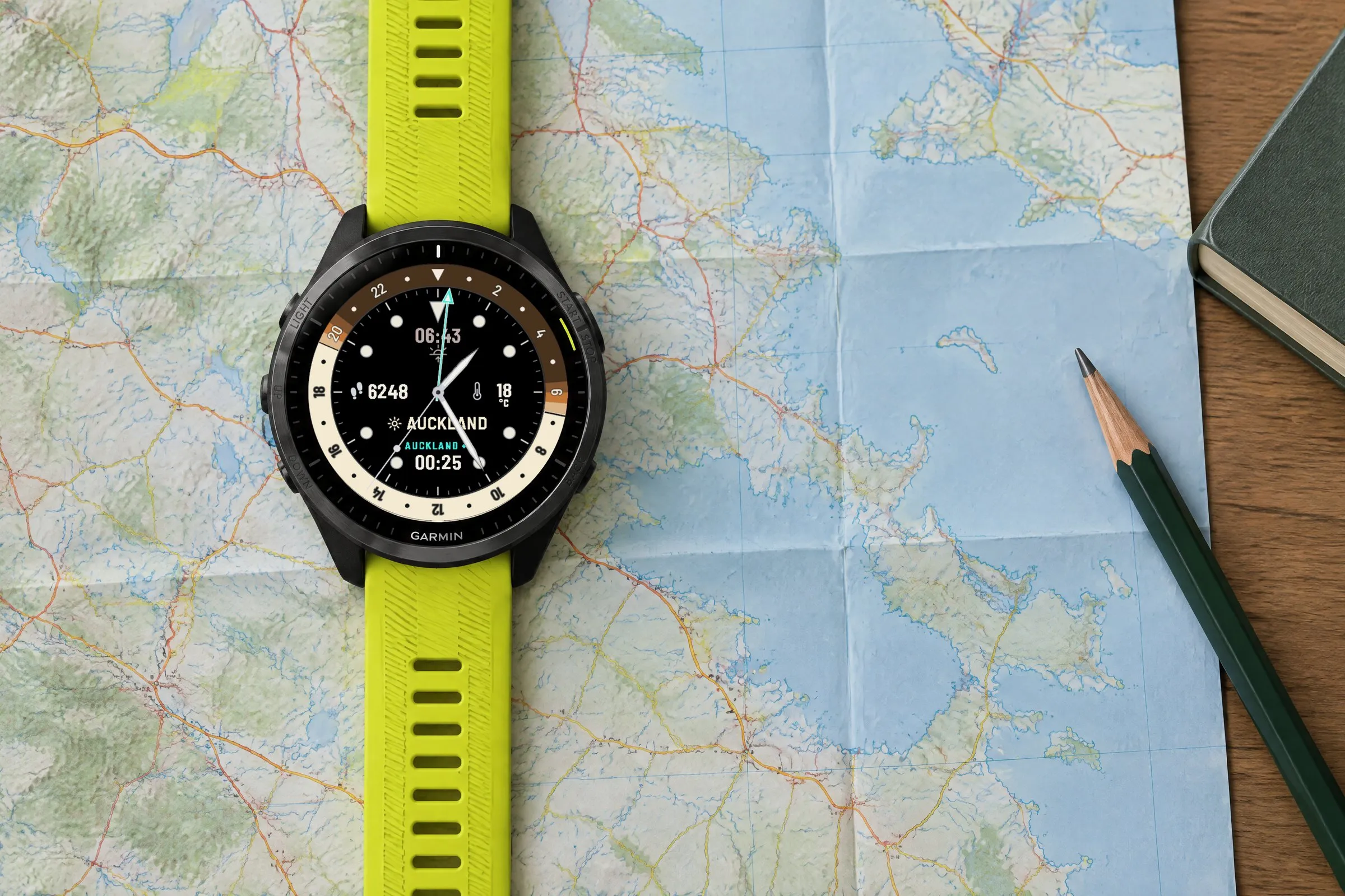 Garmin Forerunner 965 with the analog GMT watch face Horizon GMT in Toffee on a paper map, second time zone Auckland