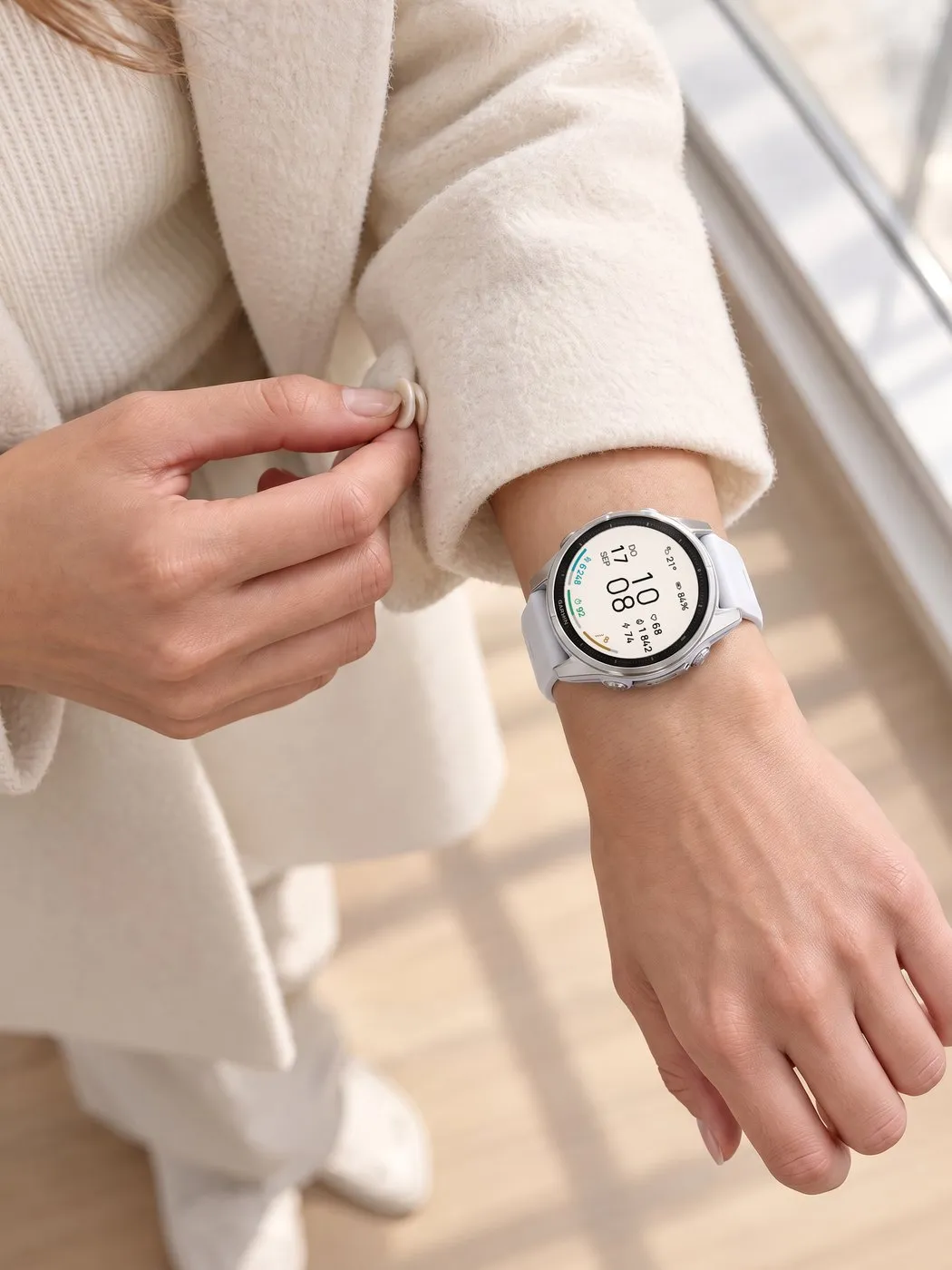 Minimal Garmin watch face ARCLINE in light mode on a white fēnix 8 at the sleeve of a cream coat