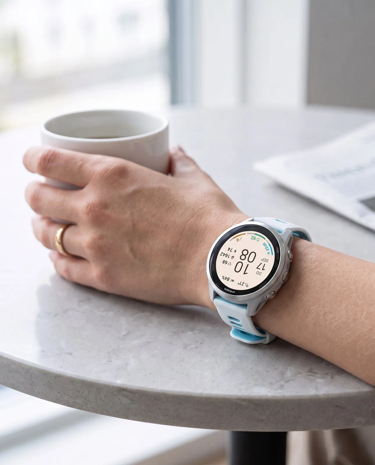 Minimal Garmin watch face ARCLINE in light mode on a Forerunner 570 on the wrist over coffee