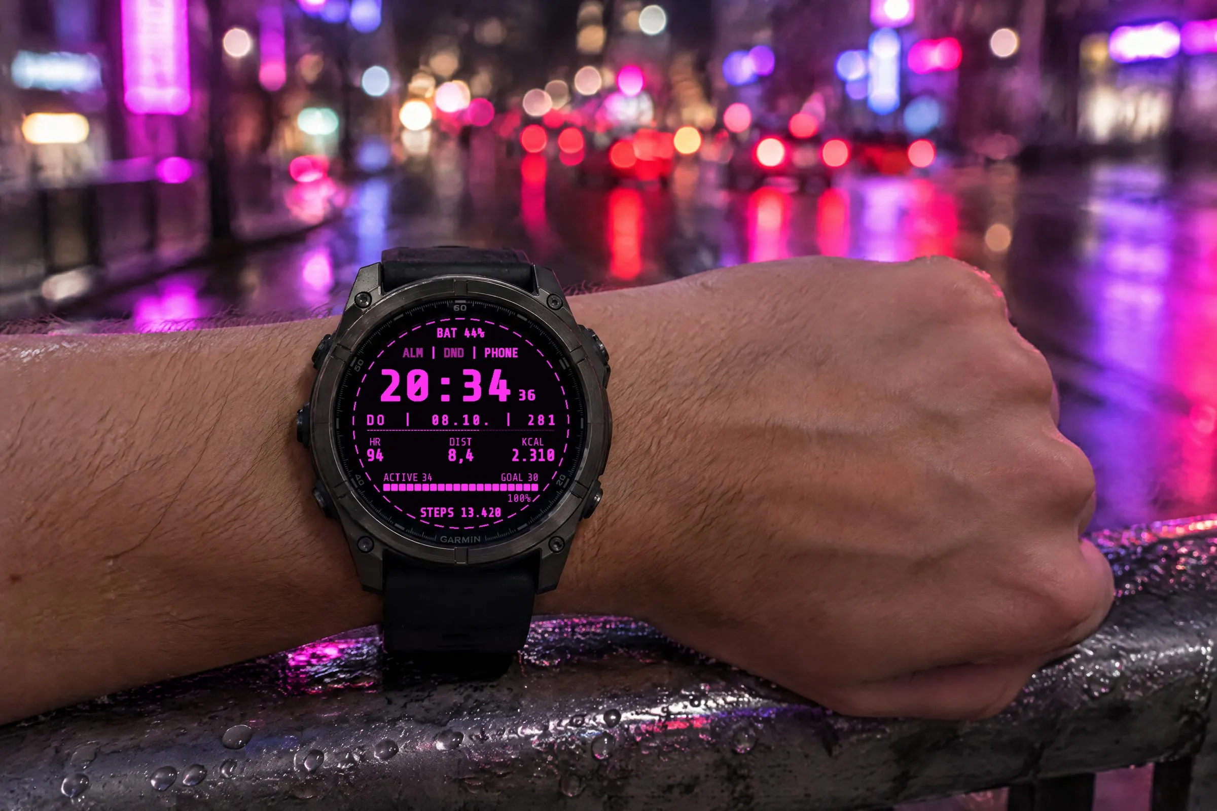Garmin fēnix 8 mit dem Retro Watch Face Terminal in Neonrosa am Handgelenk auf einer Brücke bei Nacht