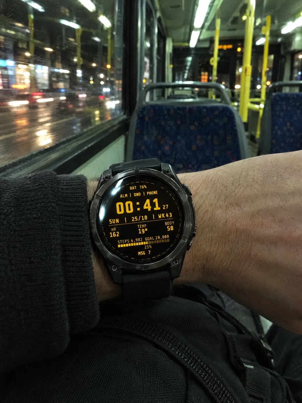 Retro Garmin watch face Terminal in amber on a fēnix 8 on a night bus