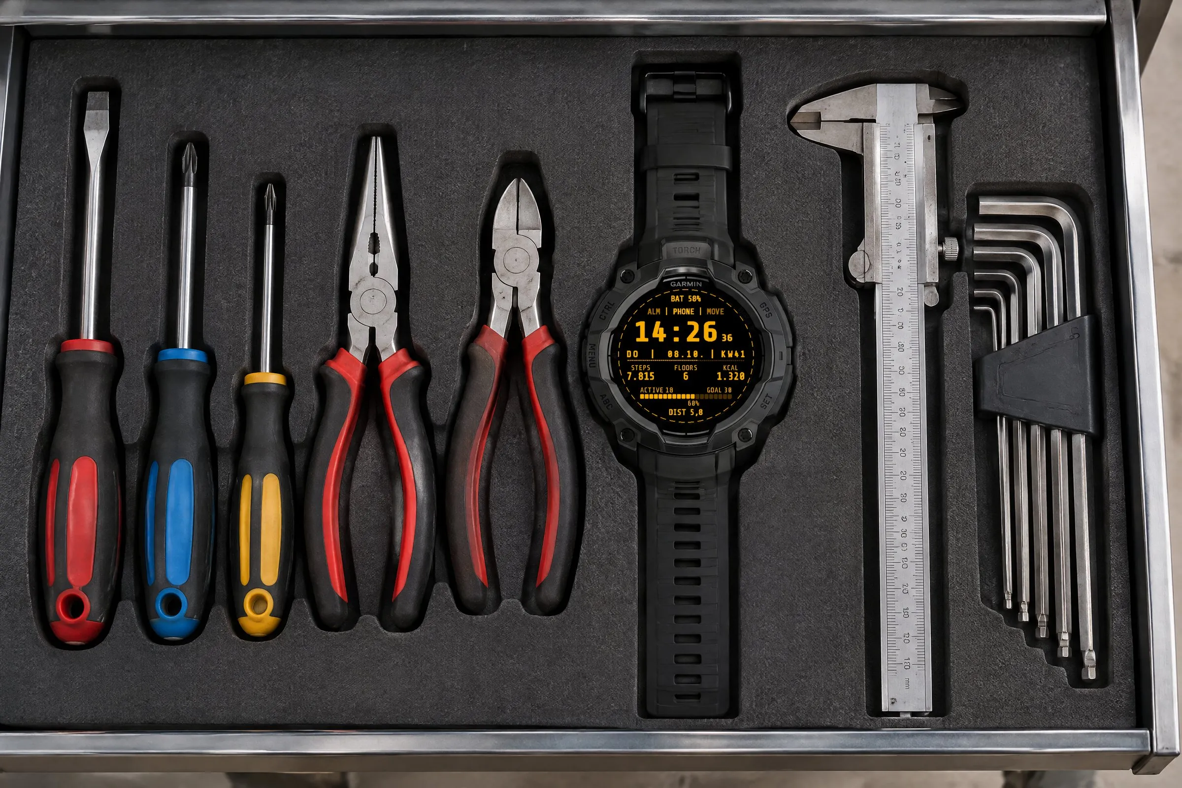 Garmin Instinct 3 AMOLED mit dem Retro Digital Watch Face Terminal in Bernstein in einer Werkstattschublade