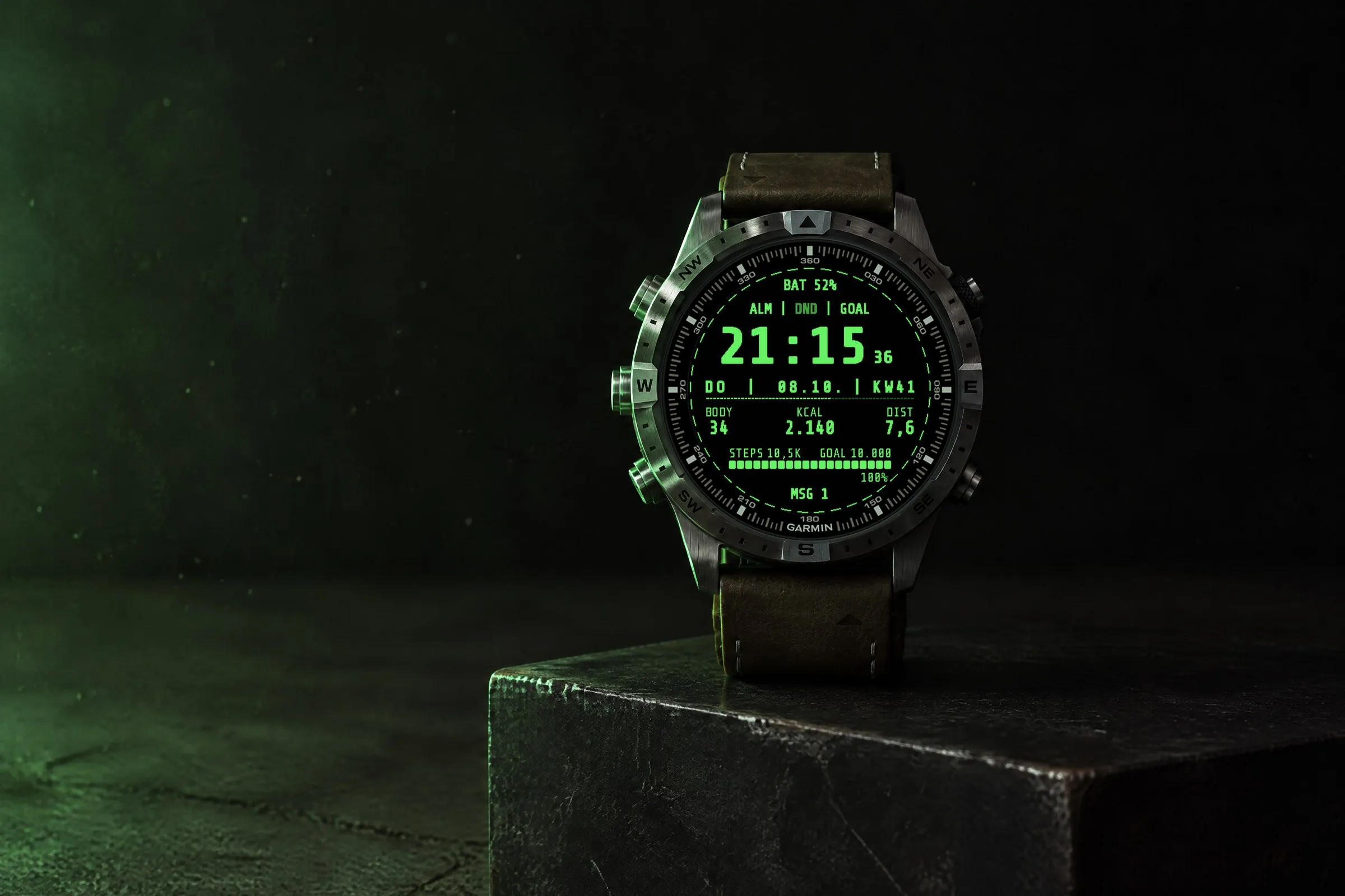 Garmin MARQ mit dem Retro Garmin Watch Face Terminal in Grün auf einem schwarzen Stahlblock