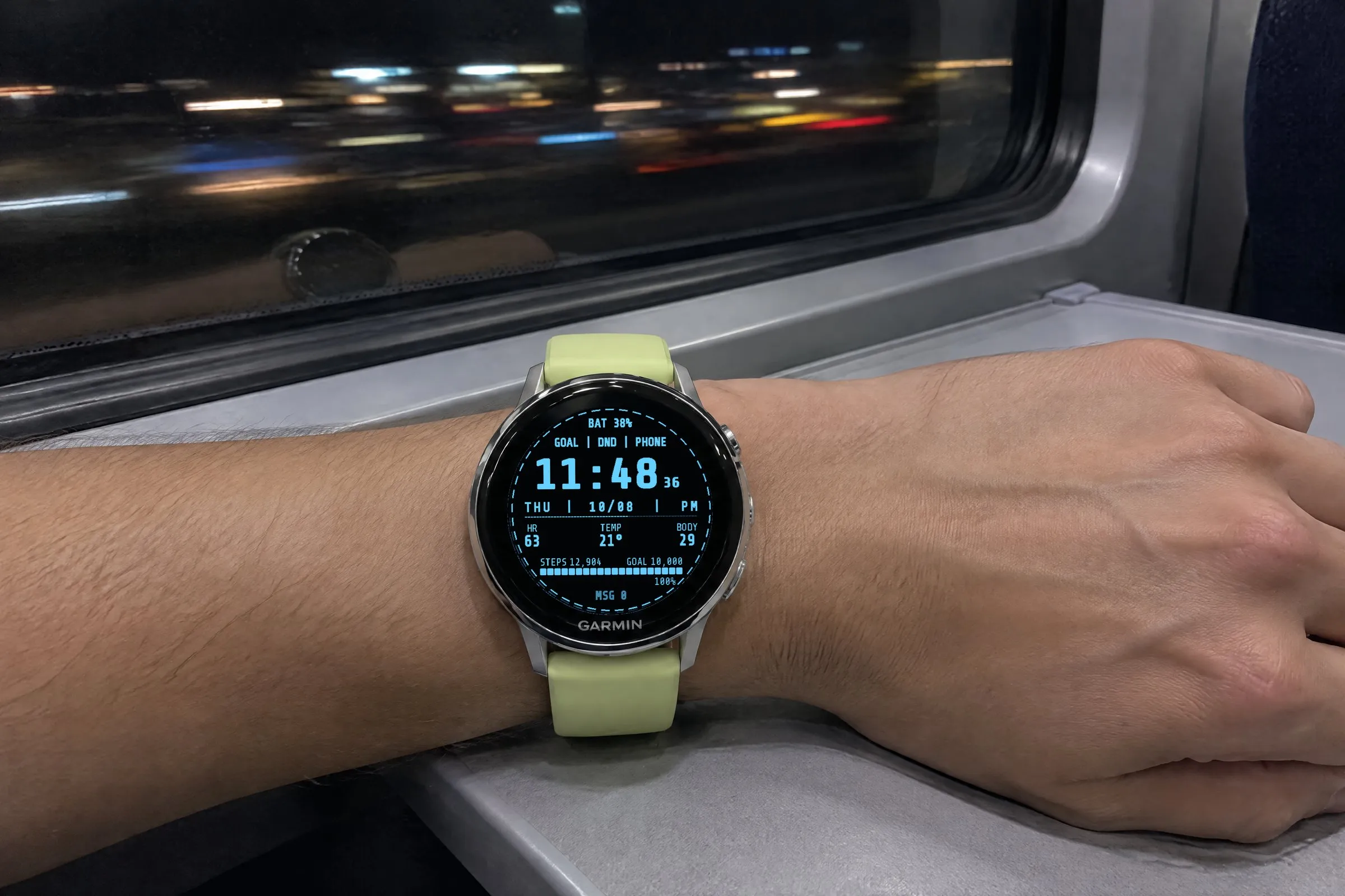 Garmin Venu 4 with the Terminal Garmin watch face in ice blue on the wrist on a night train